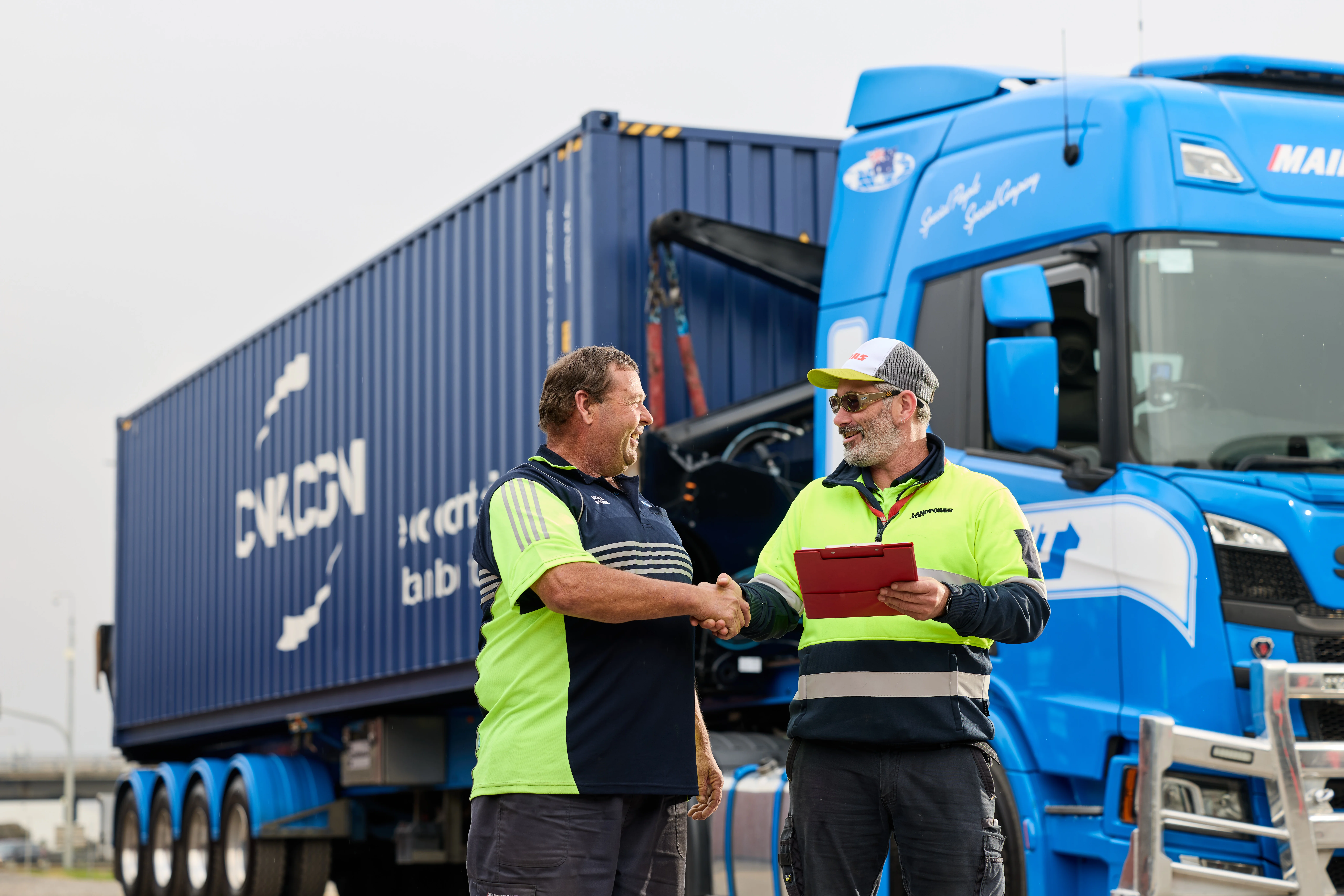 Mainfreight - Container - Transport - Sideloader - Mainfreight Team member in front of a side loader container truck